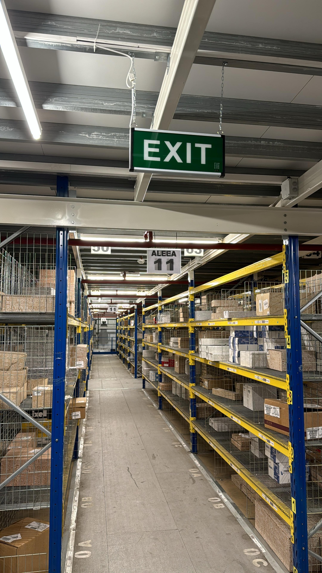 Indicator EXIT iluminat antipanică suspendat pe culoar depozit piese Dacia Oarja
